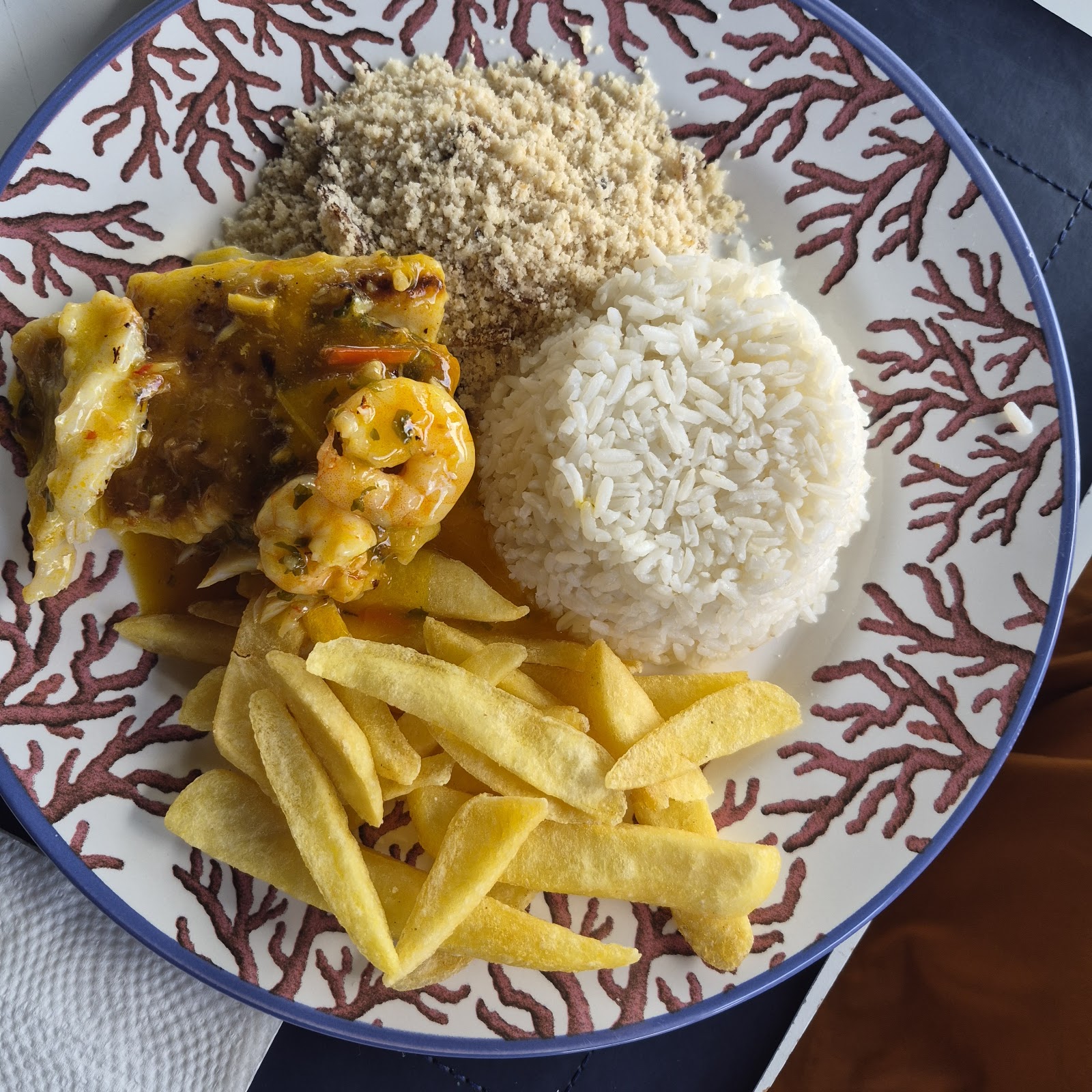 Prato de camarões com arroz, farofa e batatas