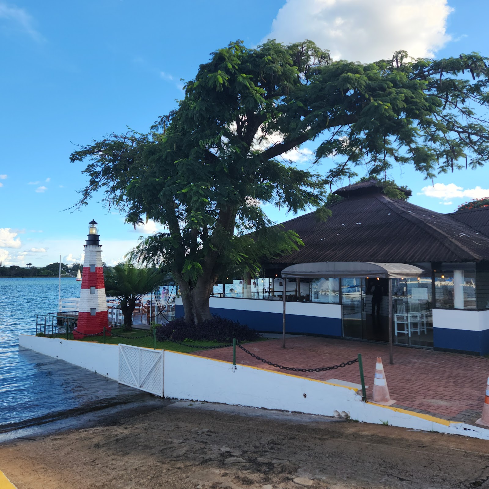 Fachada do Farol com árvore e farol listrado